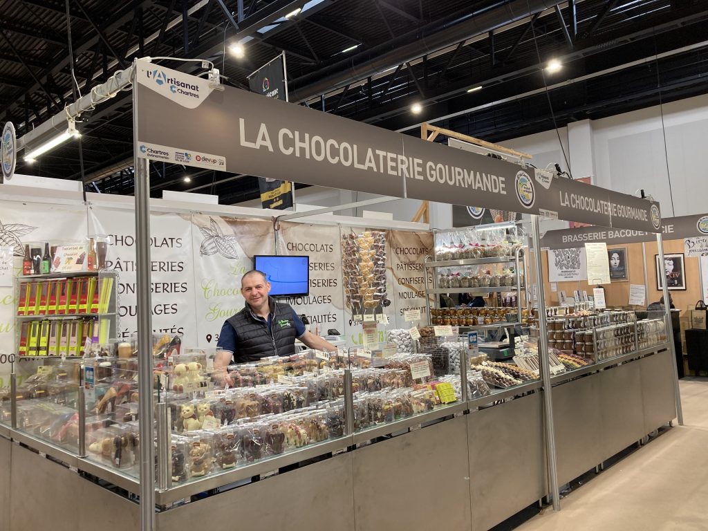 Le stand de la chocolaterie gourmande avec un bel assortiment de chocolat.